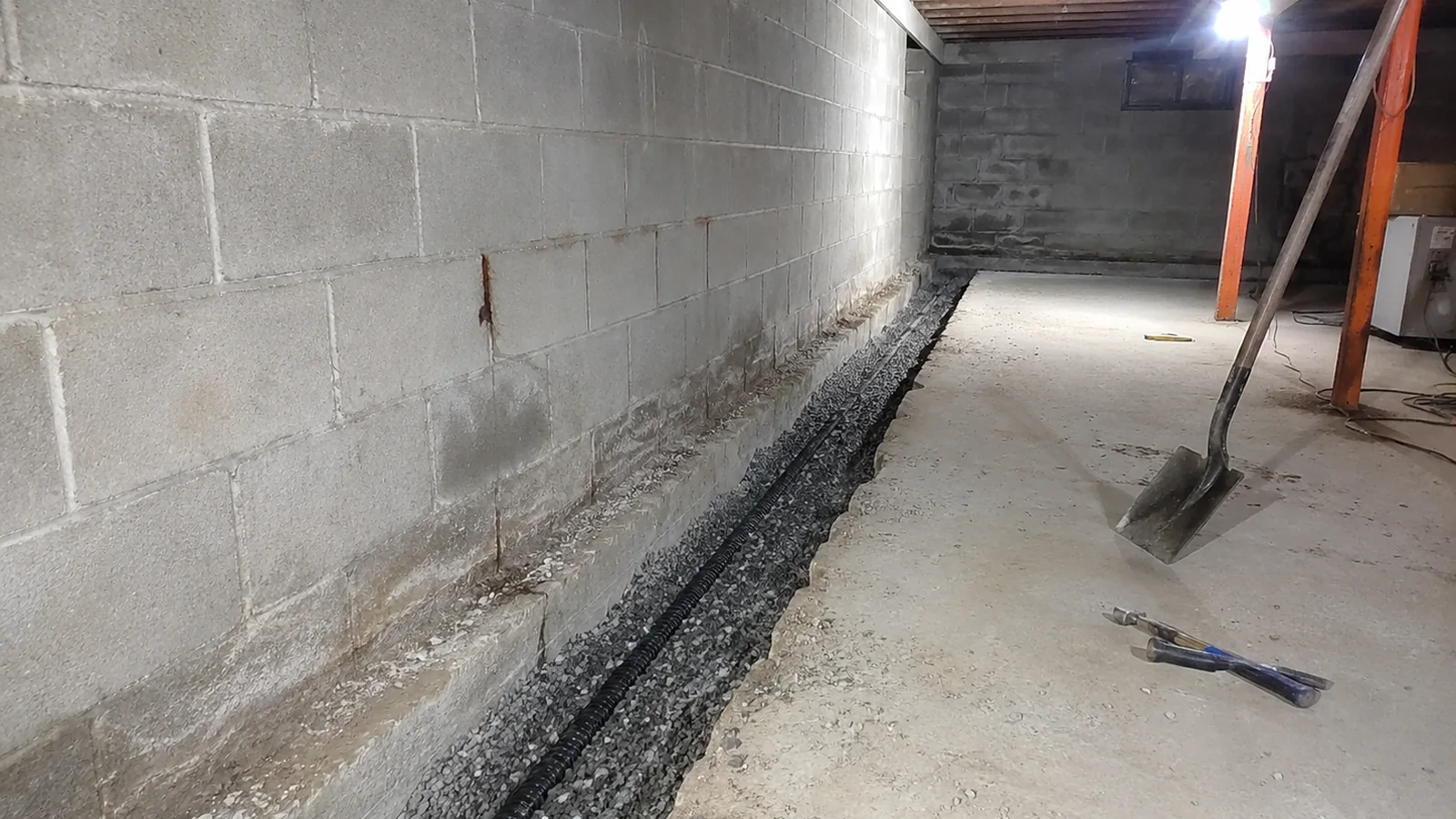 Interior drainage trench and sump connection in a basement